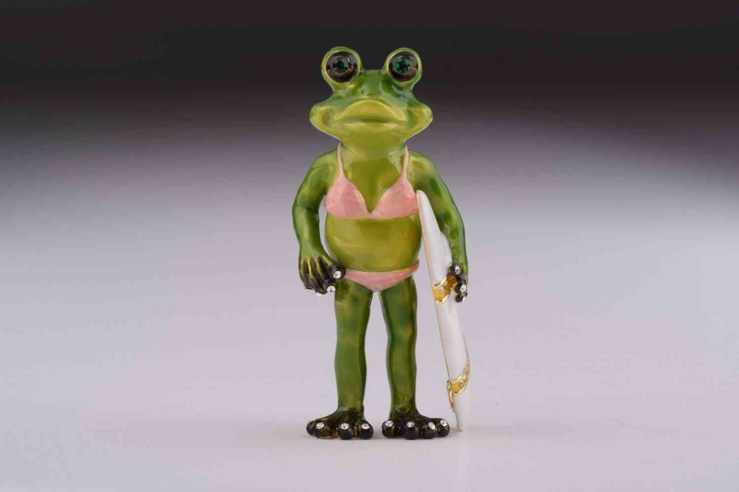 žaba, ki drži škatlo za nakit za desko