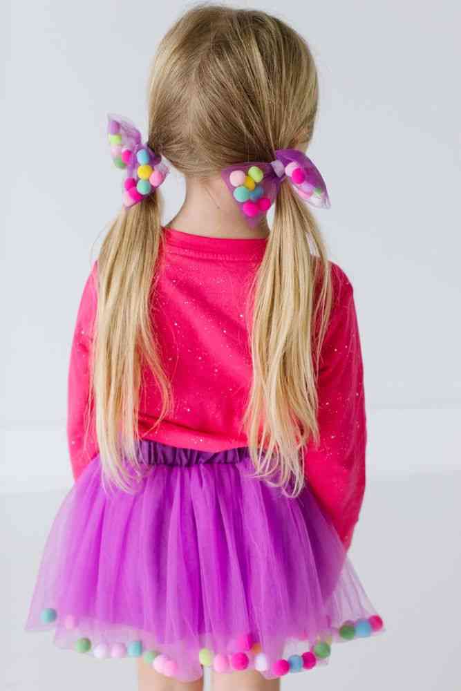 Falda con bolas multicolores y lazo en el pelo