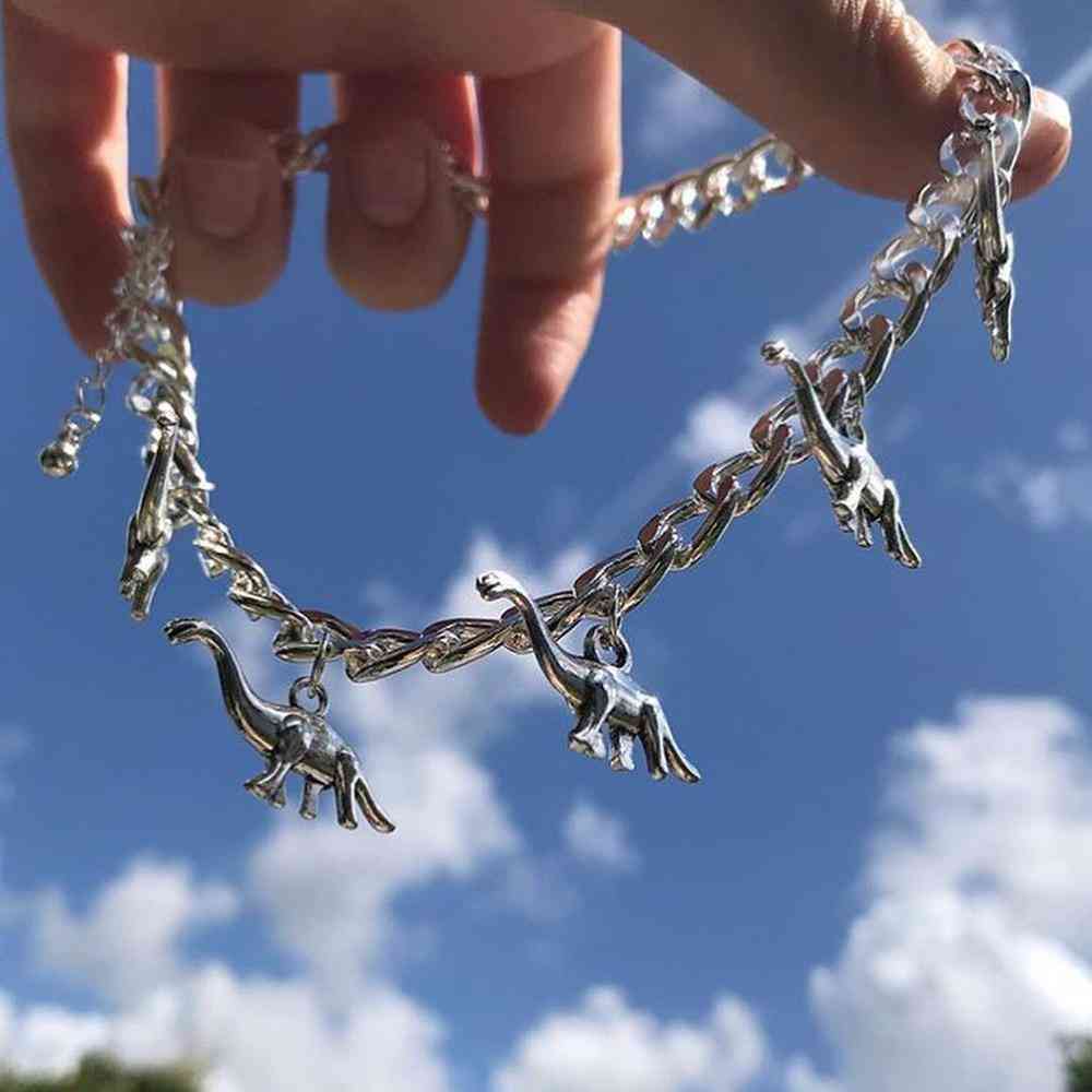 Kovový náhrdelník s príveskom v tvare dinosaura, dievča